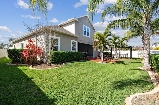 rear view of property featuring a patio, a yard, and a gazebo