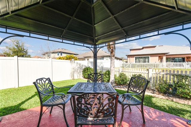 view of patio with a gazebo, outdoor dining area, and a fenced backyard