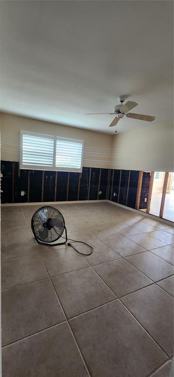 unfurnished room featuring tile patterned flooring, a wealth of natural light, and ceiling fan