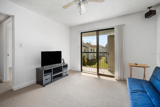 carpeted living room with ceiling fan and a textured ceiling