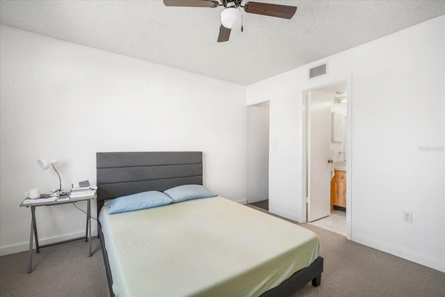 carpeted bedroom featuring ceiling fan, connected bathroom, and a textured ceiling