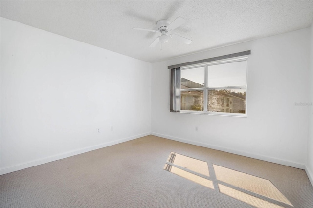 carpeted empty room featuring ceiling fan and a textured ceiling