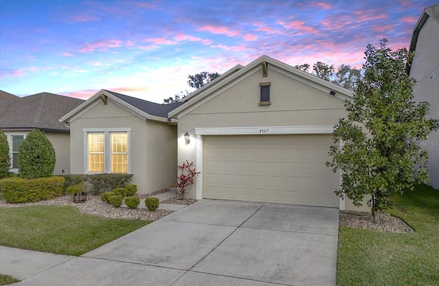 single story home featuring a garage and a yard