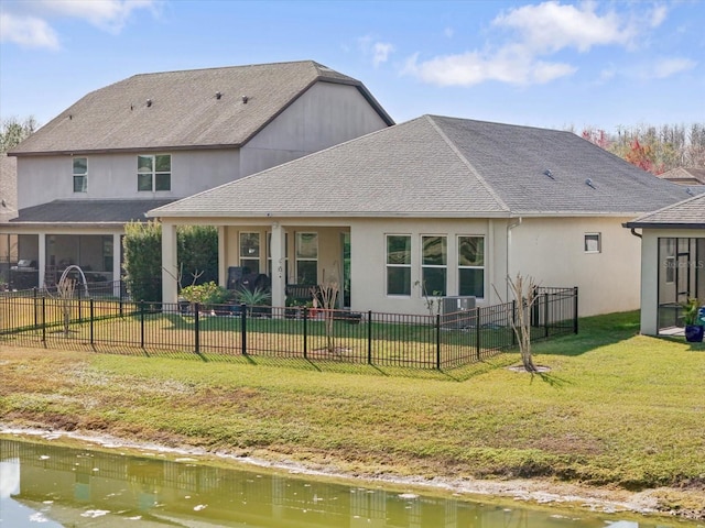 rear view of house featuring a water view and a yard