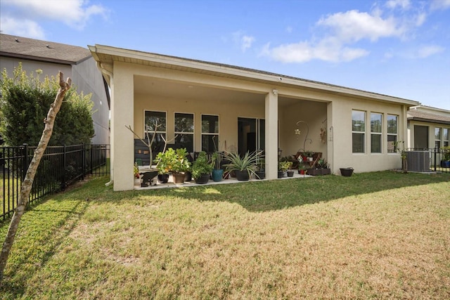 rear view of property featuring a yard and central AC unit