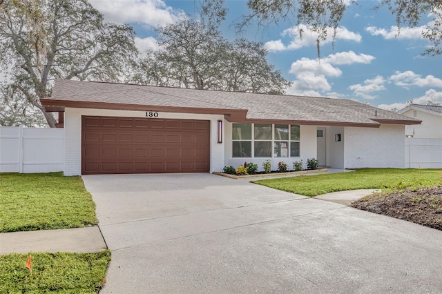 ranch-style house featuring a garage and a front lawn