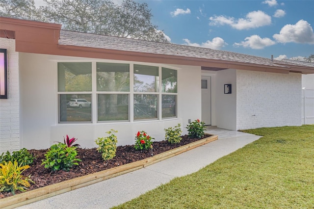 view of exterior entry featuring a yard