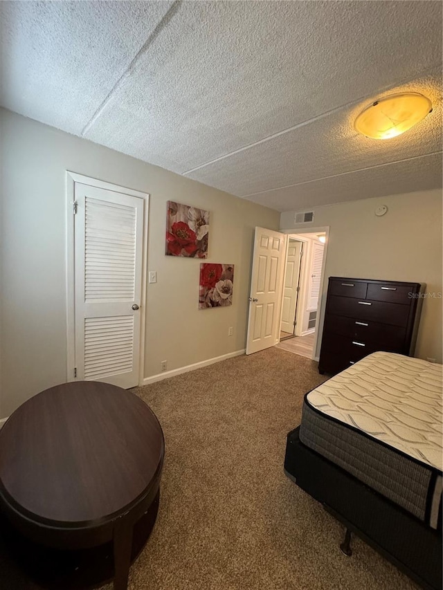 bedroom with carpet floors and a textured ceiling