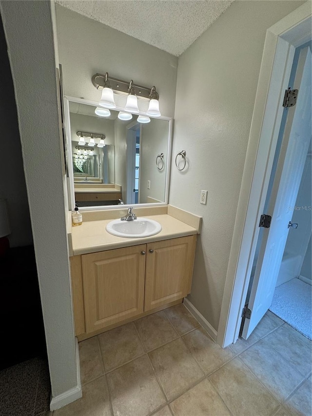 bathroom featuring vanity, tile patterned floors, and a textured ceiling