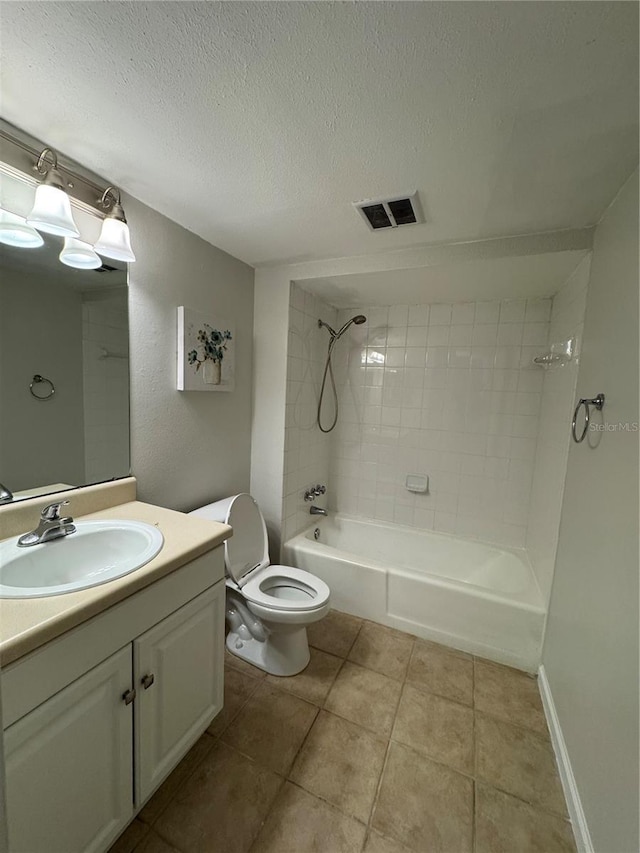 full bathroom with vanity, a textured ceiling, tiled shower / bath, tile patterned floors, and toilet