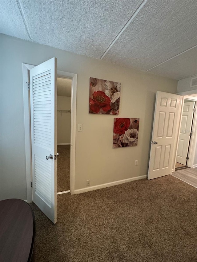 interior space with a textured ceiling and dark carpet