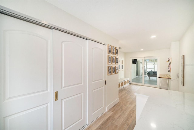 corridor with light hardwood / wood-style flooring