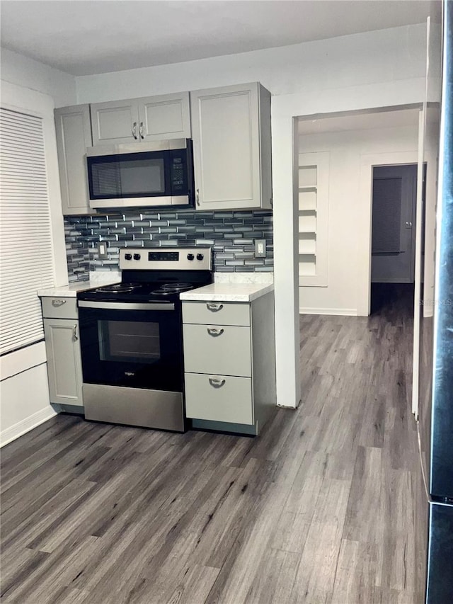 kitchen featuring appliances with stainless steel finishes, dark hardwood / wood-style floors, and gray cabinets