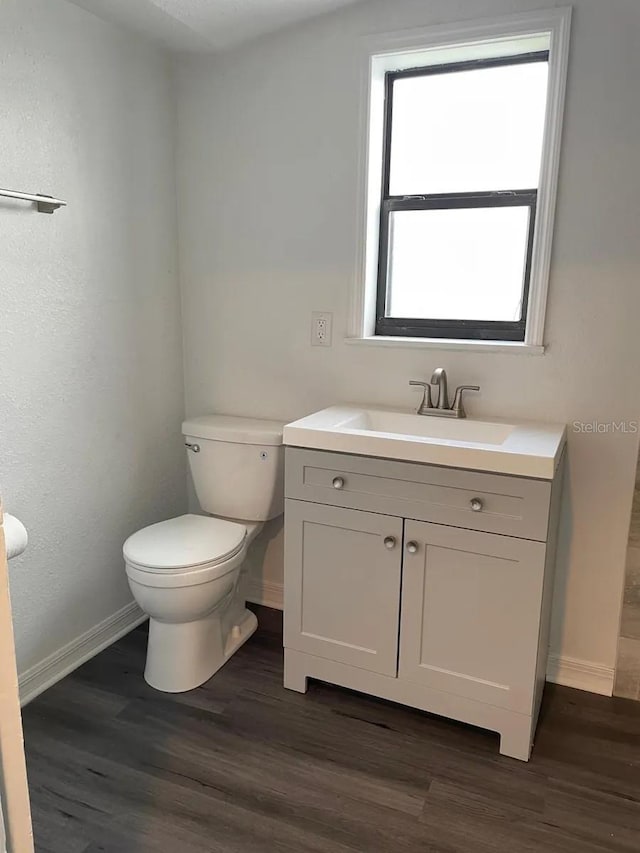 bathroom featuring hardwood / wood-style flooring, vanity, and toilet