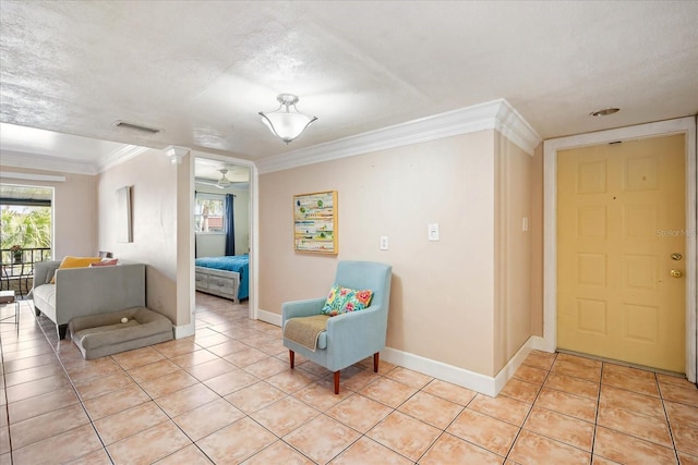 sitting room with light tile patterned floors, ornamental molding, and a textured ceiling