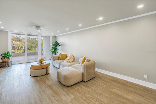 living room with crown molding, ceiling fan, and light wood-type flooring