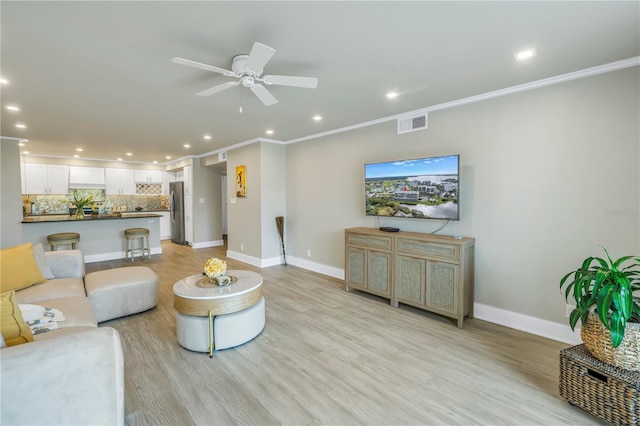 living room with ceiling fan, ornamental molding, and light hardwood / wood-style floors