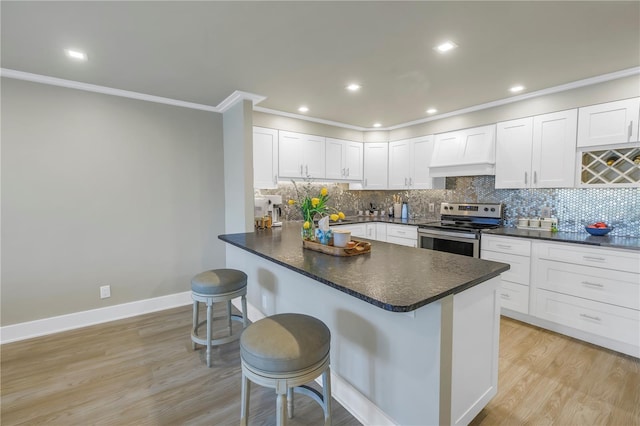 kitchen featuring electric stove, a kitchen bar, kitchen peninsula, and custom exhaust hood