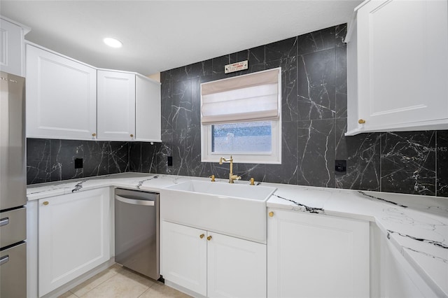 kitchen featuring white cabinetry, decorative backsplash, light stone countertops, and appliances with stainless steel finishes