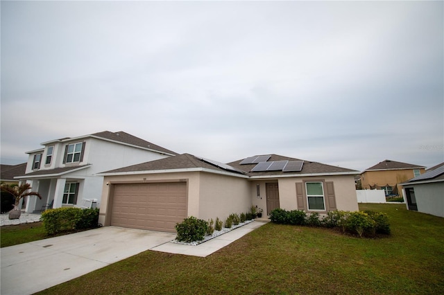 view of front of property featuring solar panels, a garage, and a front lawn