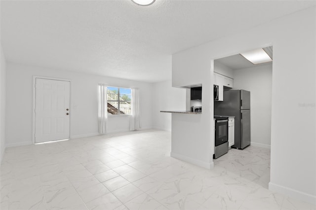 kitchen featuring stainless steel appliances, white cabinets, a textured ceiling, and kitchen peninsula