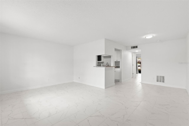 spare room with sink and a textured ceiling