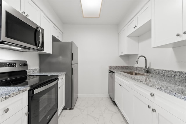 kitchen with light stone counters, sink, white cabinets, and appliances with stainless steel finishes