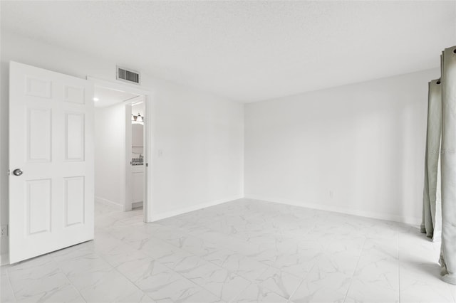 unfurnished room with a textured ceiling