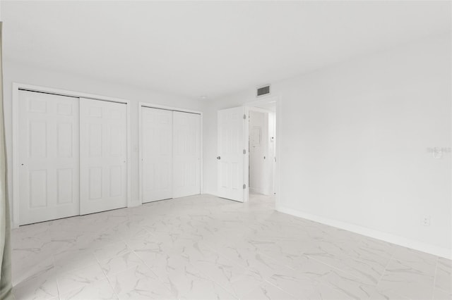 unfurnished bedroom with multiple closets