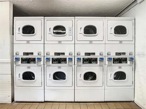 laundry room featuring washing machine and clothes dryer, stacked washer / dryer, and a textured ceiling