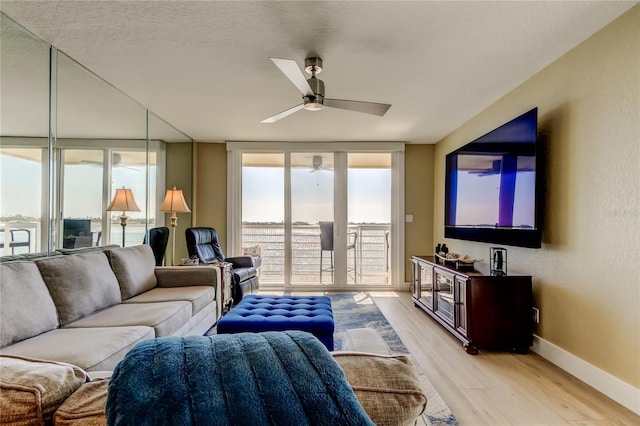 living room with a textured ceiling, light hardwood / wood-style floors, floor to ceiling windows, and ceiling fan