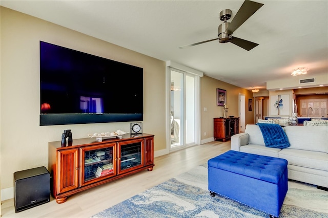 living room with ceiling fan, sink, and light hardwood / wood-style floors