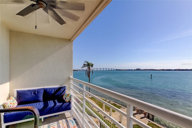 balcony with ceiling fan and a water view