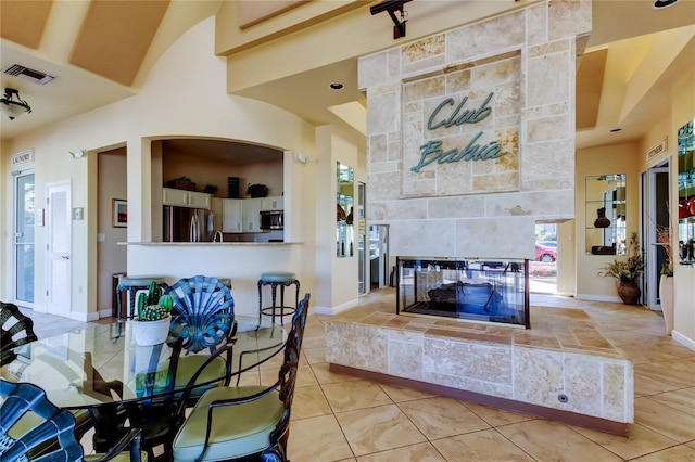 dining area with light tile patterned floors and a tile fireplace