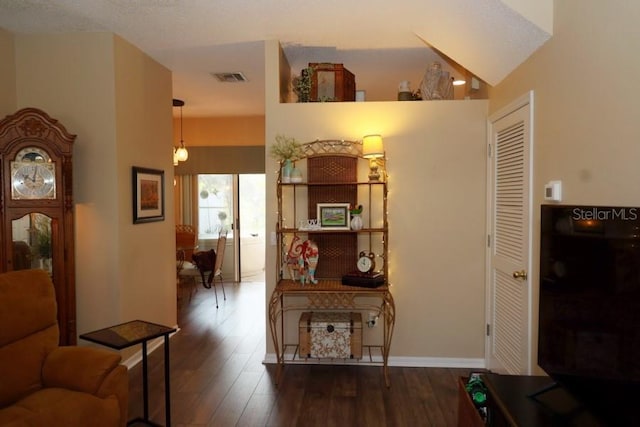 corridor featuring dark hardwood / wood-style floors and vaulted ceiling