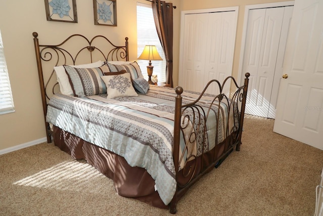 bedroom with carpet floors, multiple windows, and two closets