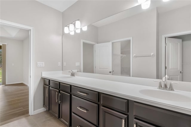 full bath with double vanity and baseboards