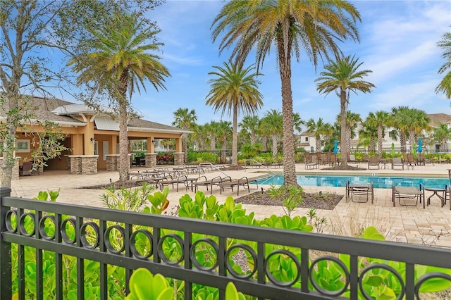 community pool with a patio and fence