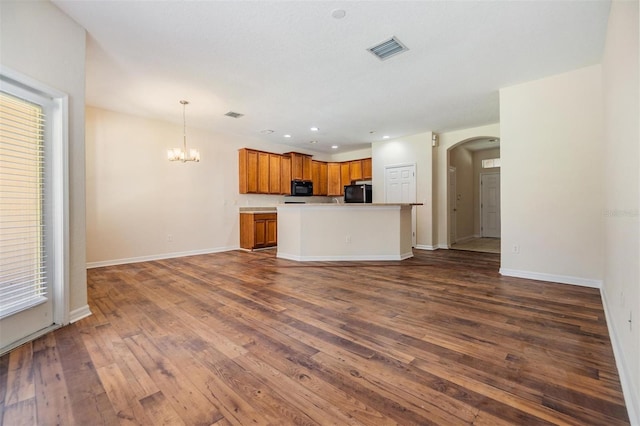 kitchen with an inviting chandelier, decorative light fixtures, dark hardwood / wood-style flooring, and black appliances