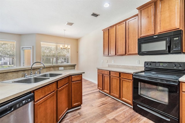 kitchen with plenty of natural light, sink, hanging light fixtures, and black appliances