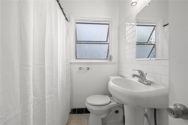 bathroom featuring tile walls, tile patterned floors, and toilet