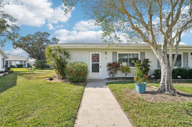 view of front facade with stucco siding and a front lawn