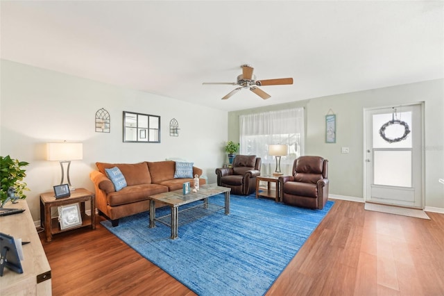 living area featuring a ceiling fan, wood finished floors, and baseboards