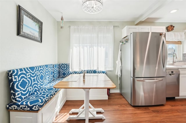 kitchen featuring white cabinetry, hardwood / wood-style floors, stainless steel appliances, and sink