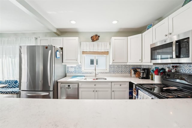 kitchen featuring appliances with stainless steel finishes, sink, and white cabinets