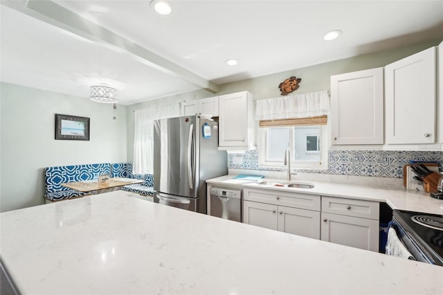 kitchen featuring sink, white cabinetry, tasteful backsplash, appliances with stainless steel finishes, and beam ceiling