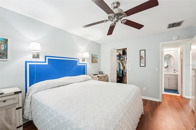 bedroom featuring a spacious closet, dark hardwood / wood-style floors, ceiling fan, and a closet