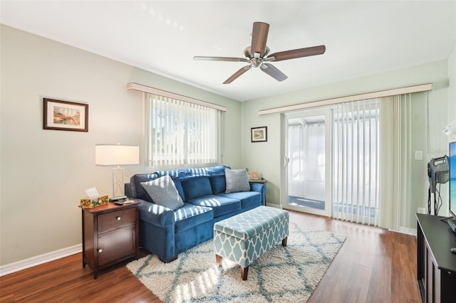 living room featuring ceiling fan and dark hardwood / wood-style flooring