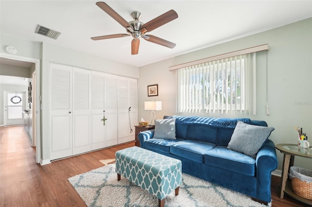 living room featuring wood-type flooring and ceiling fan