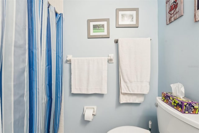 bathroom featuring walk in shower and toilet